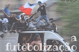Uma van em movimento com torcedores de futebol comemorando na porta lateral e sobre o teto do automóvel
