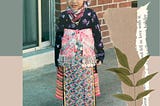 Toddler Sunshine sporting a very heavy traditional Hmong attire.