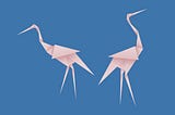 A photo of two pink flamingo paper origamis.