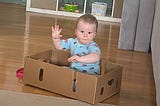 Babies like to play in boxes.