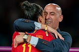 Luis Rubiales coach hugging a female player.