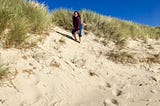 Featured biologist, Nicole, standing on a sand dune