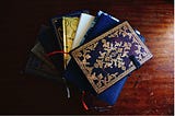 Personal journals piled on top of a desk