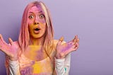 photo of a confused and shocked woman covered in colored paint at a music festival