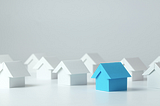 A set of toy houses set against a white backdrop