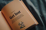 A picture of a book saying to get lost to places unknown and paths unexplored.