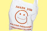 A disposable shopping bag printed with a smiling face and the message “thank you for your patronage”