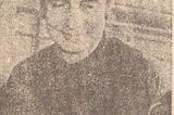 Grainy newsprint image of a dark haired man wearing a dark shirt