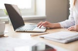 A woman typing on her laptop