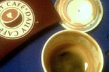 bird’s eye view of an empty espresso cup on a navy blue cafe table