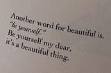 An image of a quote from a page in a printed book that reads “another word for beautiful is, “be yourself.” Be yourself my dear, it’s a beautiful thing.” The image is taken on an angle and the text takes up most of the image with a bit of plain white space around it. The text is black in a plain serif font and the background of the image is white but edited darker to be slightly greyish off white.