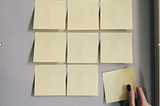 A 3 by 3 row of square blank yellow sticky notes.