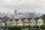 San Francisco’s iconic Victorians are surrounded, as always, by the backdrop of the City under foggy skies full of foreboding.