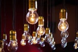 Light bulbs hanging from a ceiling, with some of them lit.