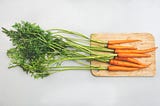 7 garden carrots on a chopping board.