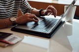 A person typing on a laptop computer.