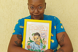 Na foto, uma mulher negra, careca, com uma camiseta azul, segura uma quadro escrito: você não pode ter medo das possibilidades