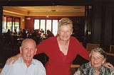 Lesley Dewar in a red top, with her Mum and Dad at his 95th birthday lunch