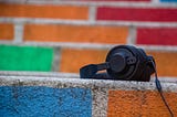 Black headphones on a multicoloured wall
