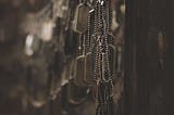 A photograph showing many military dog tags hanging