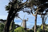 The Dutch Windmill seen between trees and shrubs in Golden Gate park