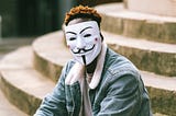 A black activist wearing an Anonymous mask as a sign of protest Photo by Anete Lusina via Pexels