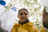 Woman putting plastic bottles in recycle bins