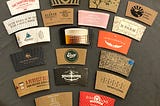 A display of coffee sleeves from a variety of shops, logos, designs, colors, and messages.