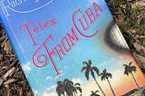 The cover of Telex From Cuba by Rachel Kushner, a Cuban beach with a red sunset, dark palm trees, and a blue sky. The page has an effect as if the paper is being burned away.