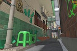 A dimly lit laneway with a green tiled wall on one side and bricks on the other. There is a plastic green chair with gumboots resting on its upturned legs.