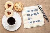 A warm display featuring coffee and cookies, accompanied by the message: “Be good to people for no reason.”