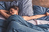 happy, well-rested woman waking up stretching