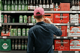Consumer in front of beer isle, going for the brand of his preference.