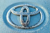 Silver tridimensional Toyota emblem photo from a car