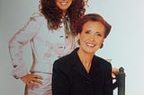 An image of Danielle Steel sitting and dressed conservatively, while behind her stands another, funkier Danielle Steel.