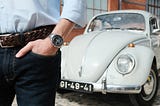 Pocket shot of the Omega Speedmaster with Bruno’s Volkswagen Beetle on the background