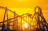 A rollercoaster in front of the golden sky of a sunset.