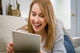 Woman with Long Golden Hair is Happy to be Voting for the Awards on her Tablet