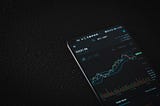 Phone with ETH stockchart up on a black background