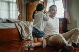 Color photo of daughter styling her father’s hair.