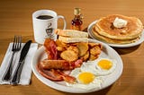 big breakfast with coffee and hotcakes eggs and hash browns