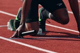 Man kneeling at the starting line about to start a race