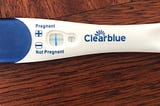 A Clear Blue pregnancy test showing a blue cross, indicating pregnancy.