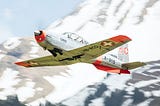 On point publishing’s chosen pic of a silver swiss sports plane flying across a mountain scene viewed from front and below with swiss flags on the place