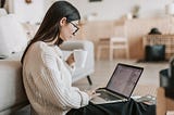 women sitting in front of her laptop writing