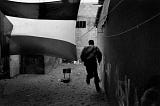 Image of a Palestinian civilian running beneath a billowing Palestinian flag