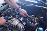 Car motor being repaired by mechanic.