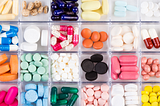 The best California Designated Representative online training courses for: Drug/Device Wholesalers | 3PL (third-party logistics providers). Image of a medication pillbox full of brightly colored pills and tablets.
