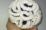 A 5 D manifold crocheted object, with the outward silhouette of a sphere