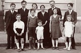 Black and white image of a large family taken a few decades ago.